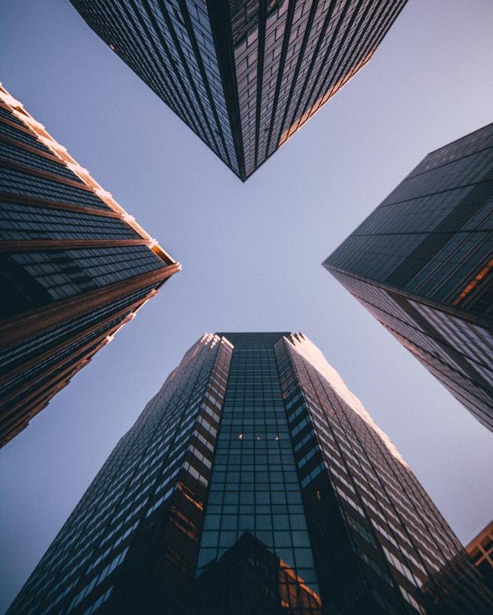 looking upwards beween 4 high rise office buildings with sky making a brilliant blue X inbetween them . ings 