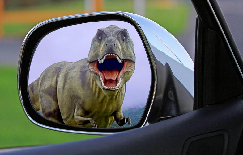 T Rex with mouth open in car side view mirror